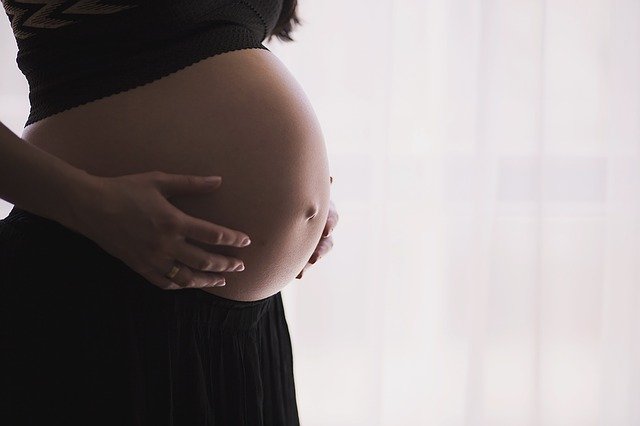 Schwangere Frau hält sich den Bauch