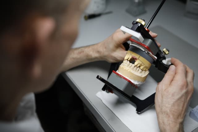 Zahntechniker arbeitet an einem Modell